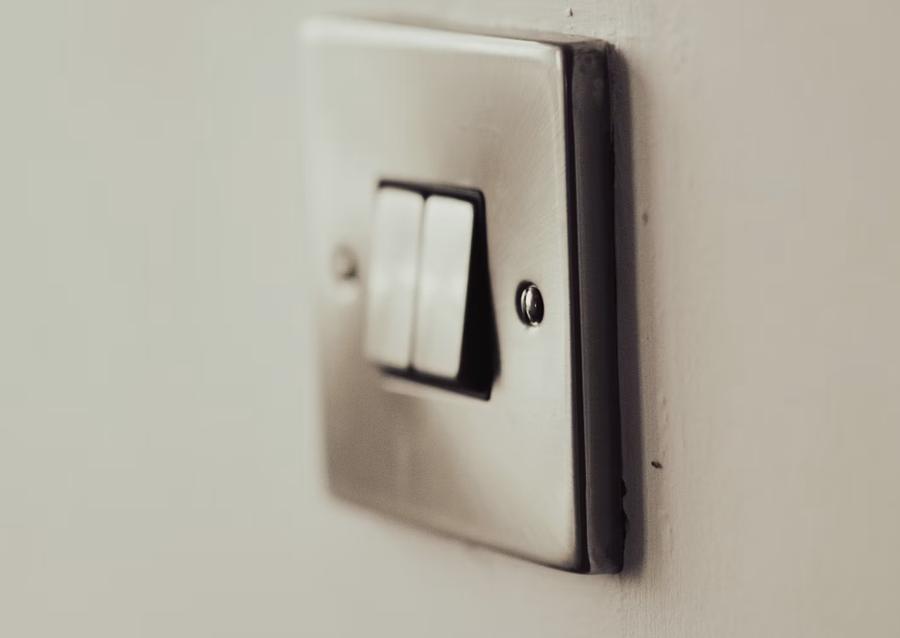 Interrupteur double en métal brossé sur un mur clair
